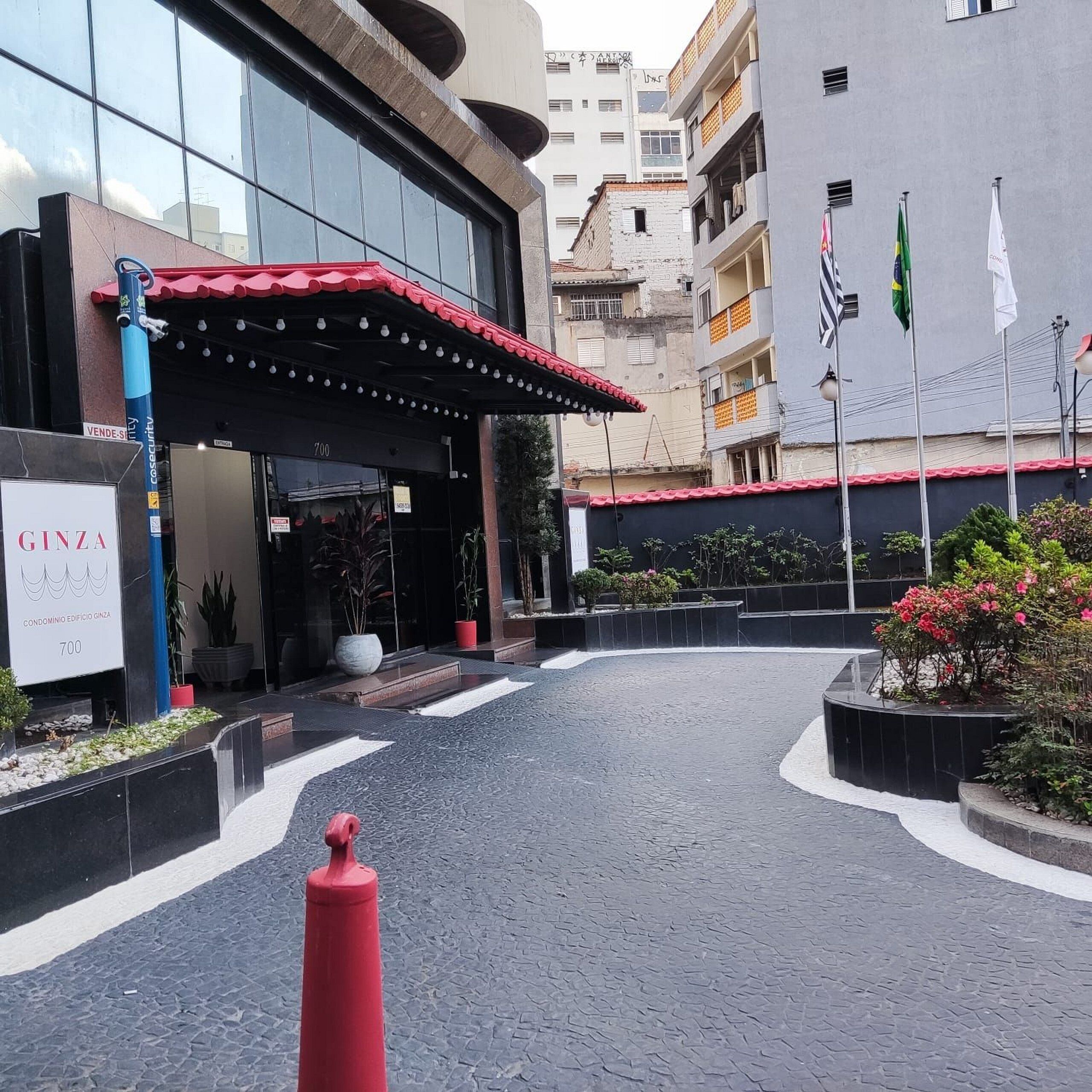 Un bâtiment doté d’un auvent rouge, d’une enseigne indiquant « GINZA » et d’un chemin pavé menant à l’entrée.