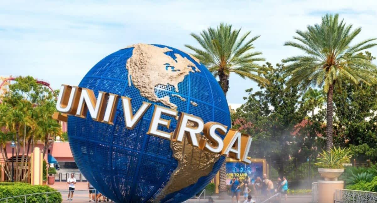 A large globe with 'UNIVERSAL' written on it, surrounded by palm trees and a clear sky.