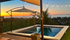 A pool area with a view of the sunset, a covered seating area, and a potted plant. - house with a beautiful sea view in enchanting SurfCity with WiFi, AC and Pool. (La Libertad)