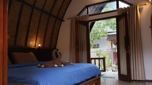 A bedroom with a bed, a wooden headboard, a window, and a view of the outside.