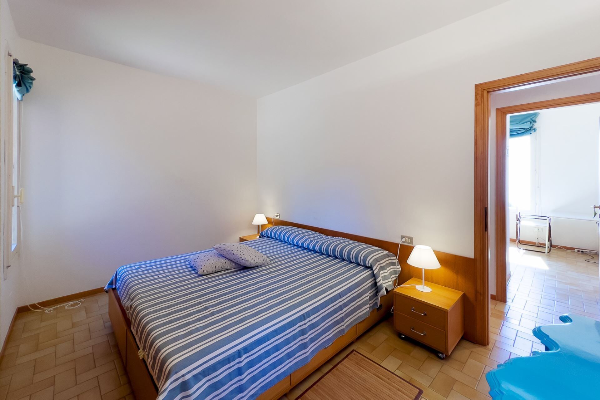 Ein Schlafzimmer mit einem Bett, Nachttischen und einem Beistelltisch.