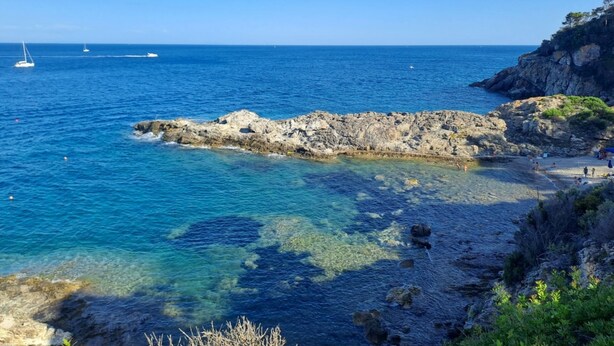 A coastal scene with clear blue water, rocky shorelines, and a few sailboats in the distance. - CASA LUISA A CAPO'DARCO - CASA LUISA (Rio Marina)