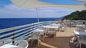 A deck with white plastic chairs and tables, overlooking the sea. - CASA LUISA A CAPO'DARCO - CASA LUISA (Rio Marina)