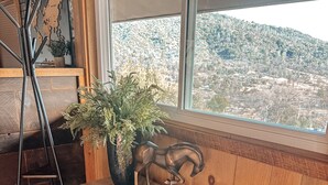 Un banco de madera con una escultura decorativa de un caballo y una planta en maceta.
