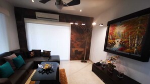 A modern living room with a sofa, coffee table, and artwork on the wall. - Charming 3-bedroom house with Private Pool in lovely Cancun (Cancun)