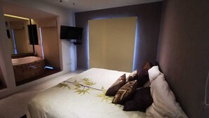 A bedroom with a bed, a television, and a window. - Charming 3-bedroom house with Private Pool in lovely Cancun (Cancun)