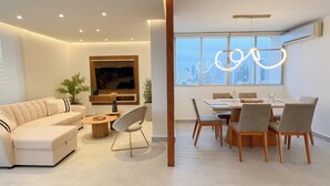 Una sala moderna con sofá, mesa de centro y comedor con sillas y una mesa.