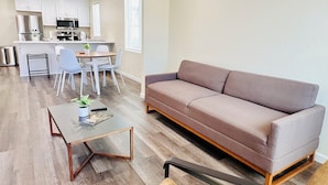 Una sala de estar moderna con un sofá, una mesa de centro y un comedor con sillas y una mesa.