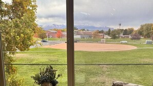 Una mesa con vista a un campo de béisbol a través de una ventana.