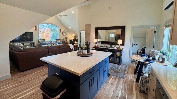 Amplia sala de estar con una isla grande, una mesa de comedor y una zona de cocina con un espejo grande.