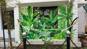 A building entrance with a mural of tropical plants and the text "The Chill House". - The Chill House (Kochi)