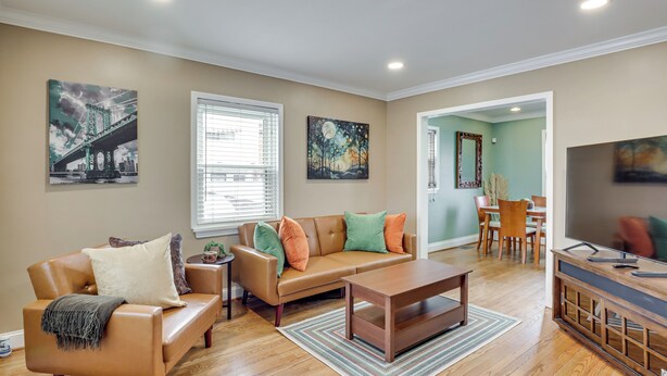 A living room with a sofa, coffee table, and artwork on the walls.