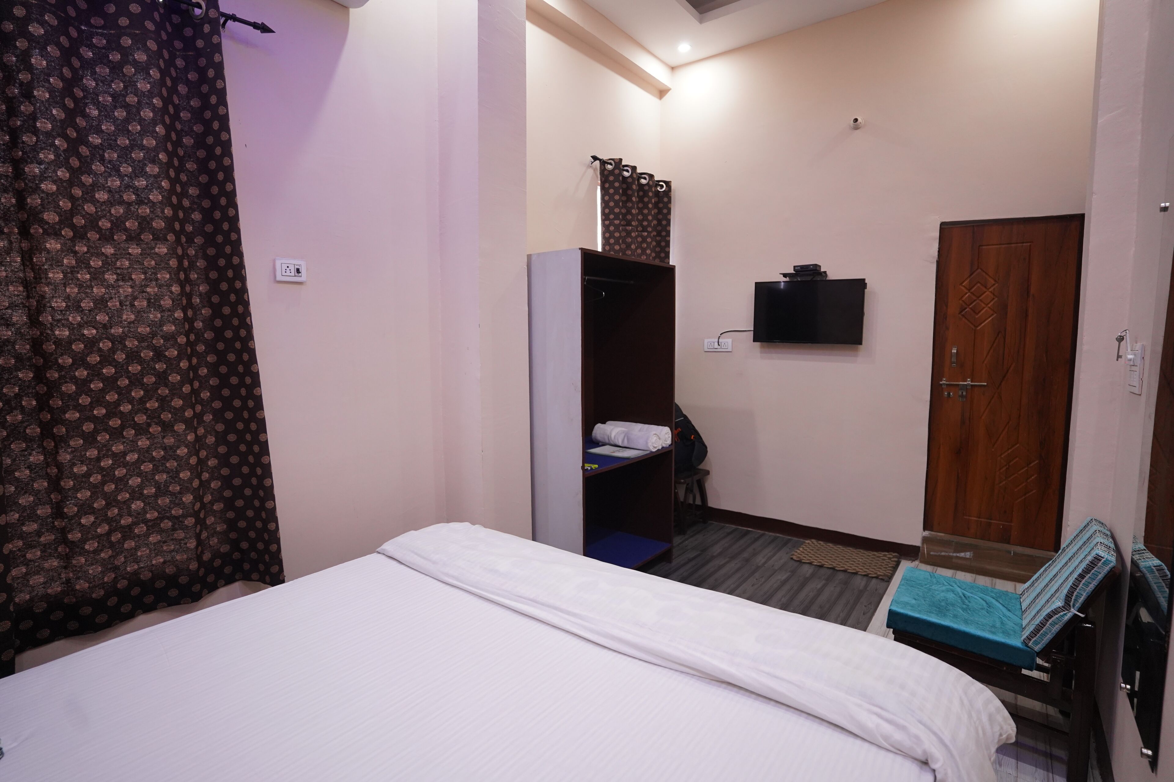Une chambre à coucher comprenant un lit, une armoire, un bureau et un téléviseur.