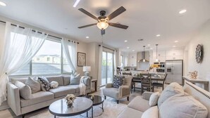 A spacious living area with a sofa set, a coffee table, and a ceiling fan. - @marbella Lane -amazing 5BR Home in Rancho Mission (San Juan Capistrano)