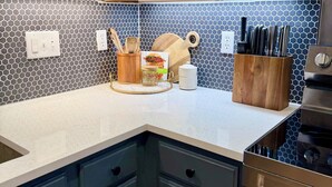 A kitchen with white cabinets, a blue hexagonal backsplash, and a stainless steel oven. - Charming 3-bedroom Georgetown house close to Square. Long term stays welcomed. (Georgetown)
