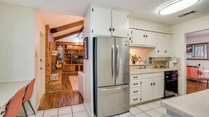 A kitchen with white cabinets, a stainless steel refrigerator, and a dishwasher.