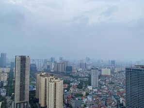 A cityscape with high-rise buildings, dense urban layout, and a cloudy sky.