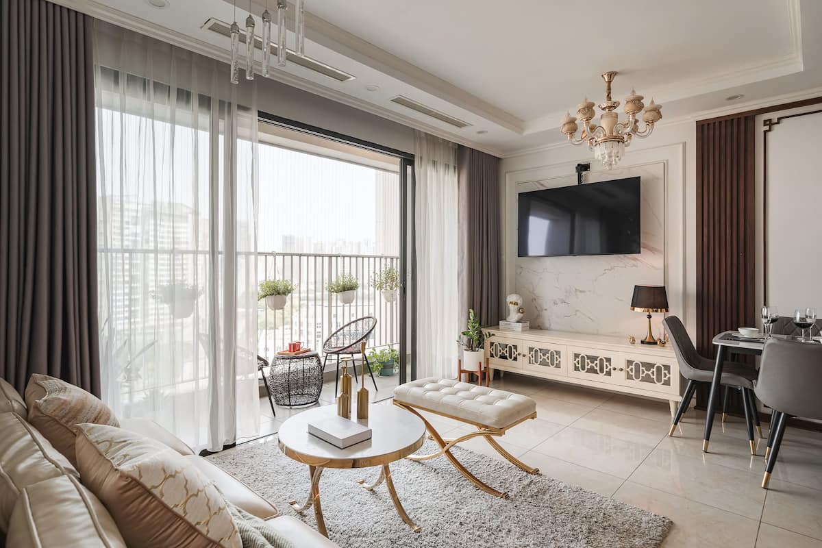 Een moderne woonkamer met een bank, een rond bijzettafeltje, en een eethoek met stoelen en een televisie.