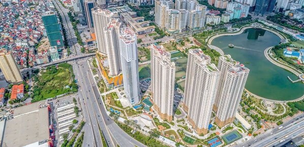 Un ensemble immobilier résidentiel composé d’immeubles de grande hauteur, de plusieurs tours, d’un parc central avec un lac et de routes avoisinantes.