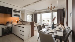 A modern kitchen with a built-in oven and a dining area with a table set for four.