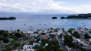 Un pueblo costero con un puerto deportivo, edificios y un puente.