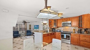 Una cocina moderna con armarios de madera, un horno de acero inoxidable y una mesa de comedor de vidrio.