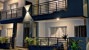 A multi-story building with balconies, large windows, and potted plants. - Akhard Haus (Buea)