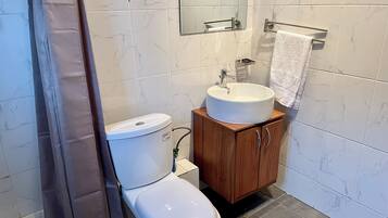 Un baño moderno con inodoro, lavabo y armario de madera.