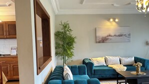 A modern living room with a sectional sofa, a coffee table, and a potted plant. - Akhard Haus (Buea)