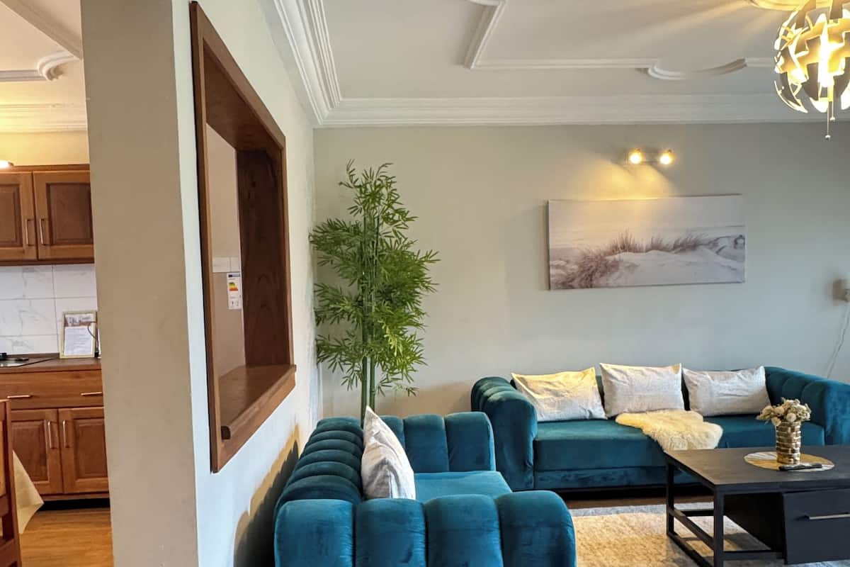 Un salon moderne avec un canapé d’angle, une table basse et une plante en pot.