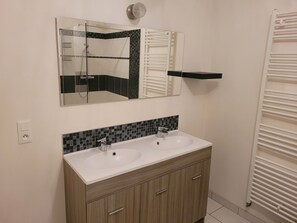A bathroom with a double sink vanity, a large mirror, and a towel rack. - Spacious duplex at Matthieu's. Sleeps 1 to 6. (Remiremont)