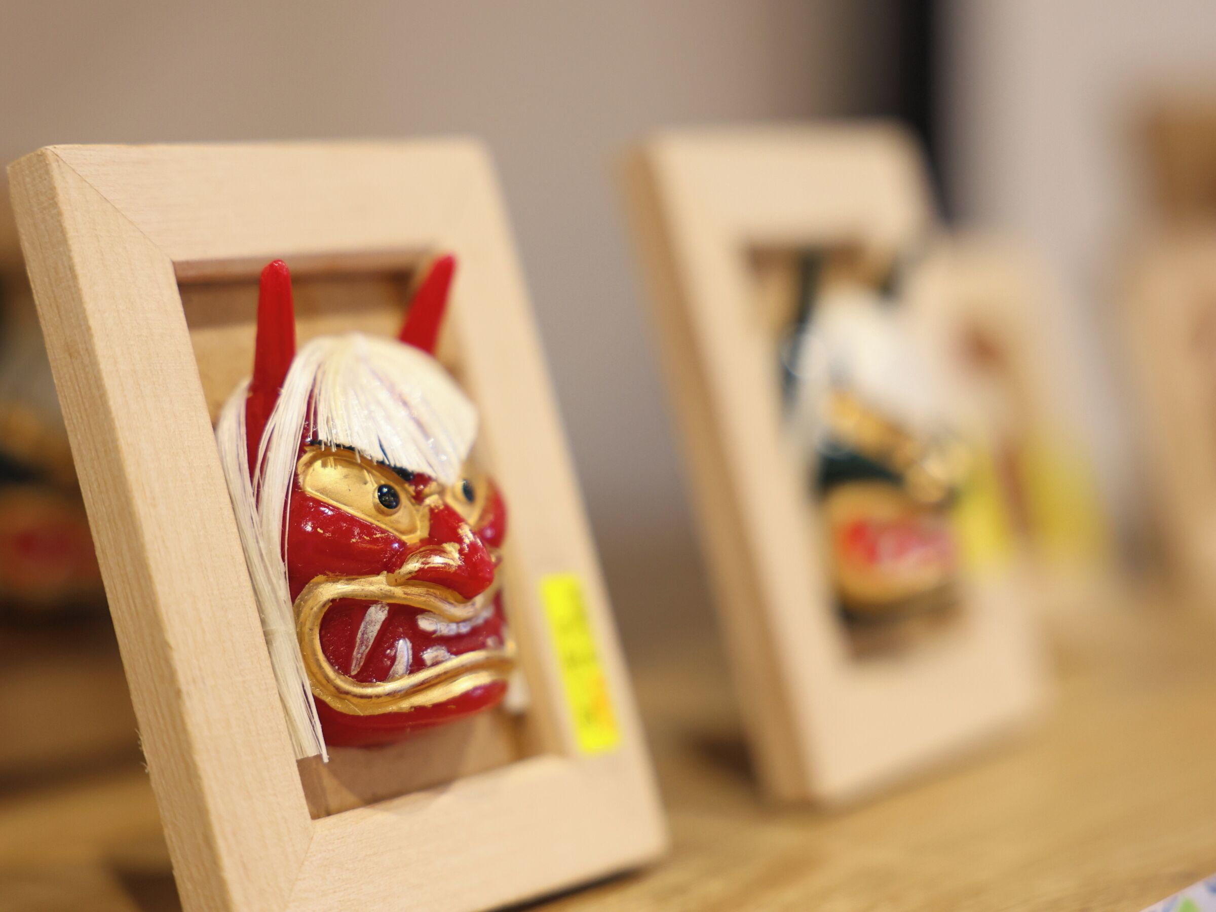 A display of traditional Japanese dolls in wooden frames.