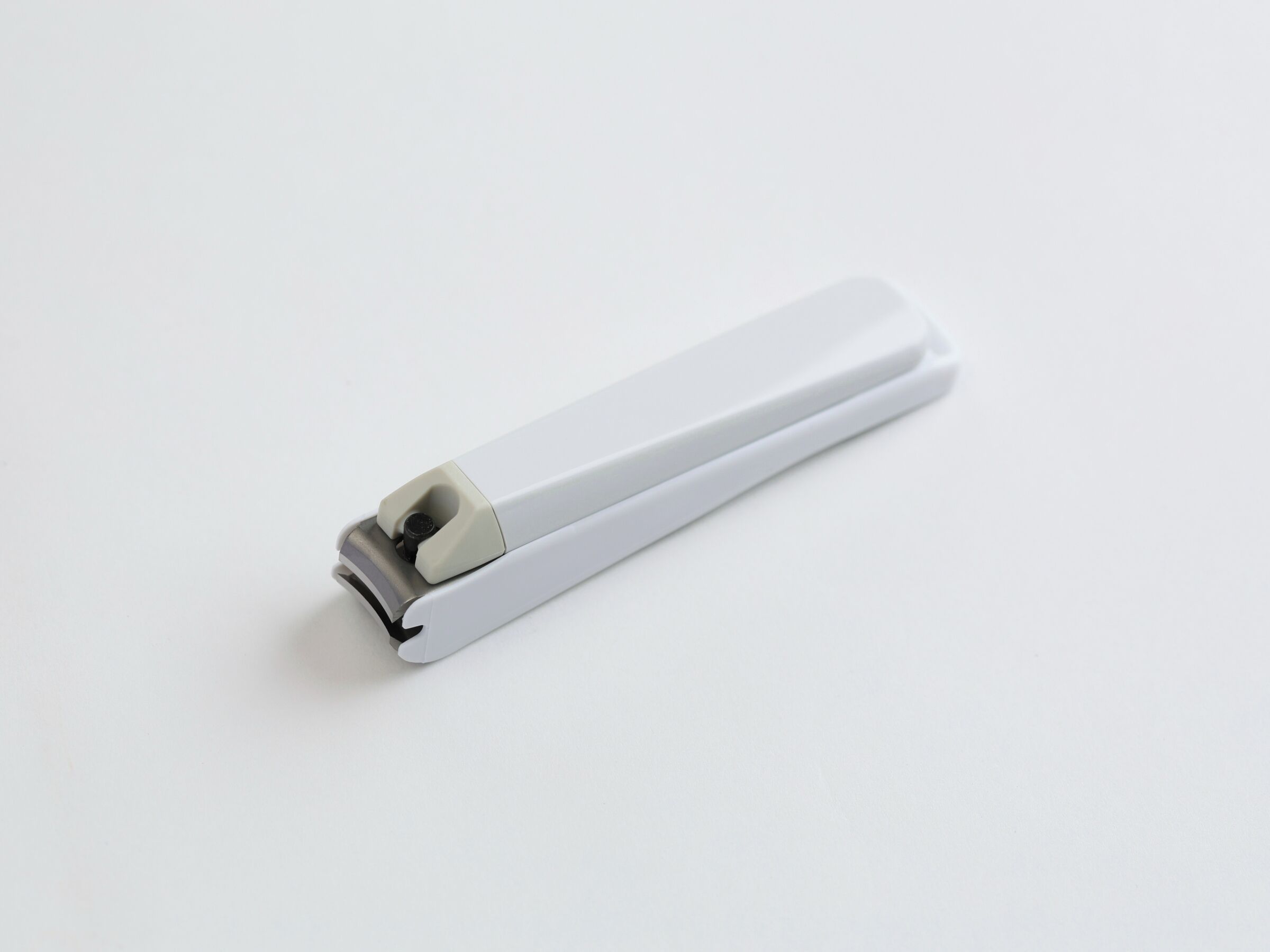 Un objeto blanco y rectangular con un extremo metálico, probablemente una herramienta o dispositivo.