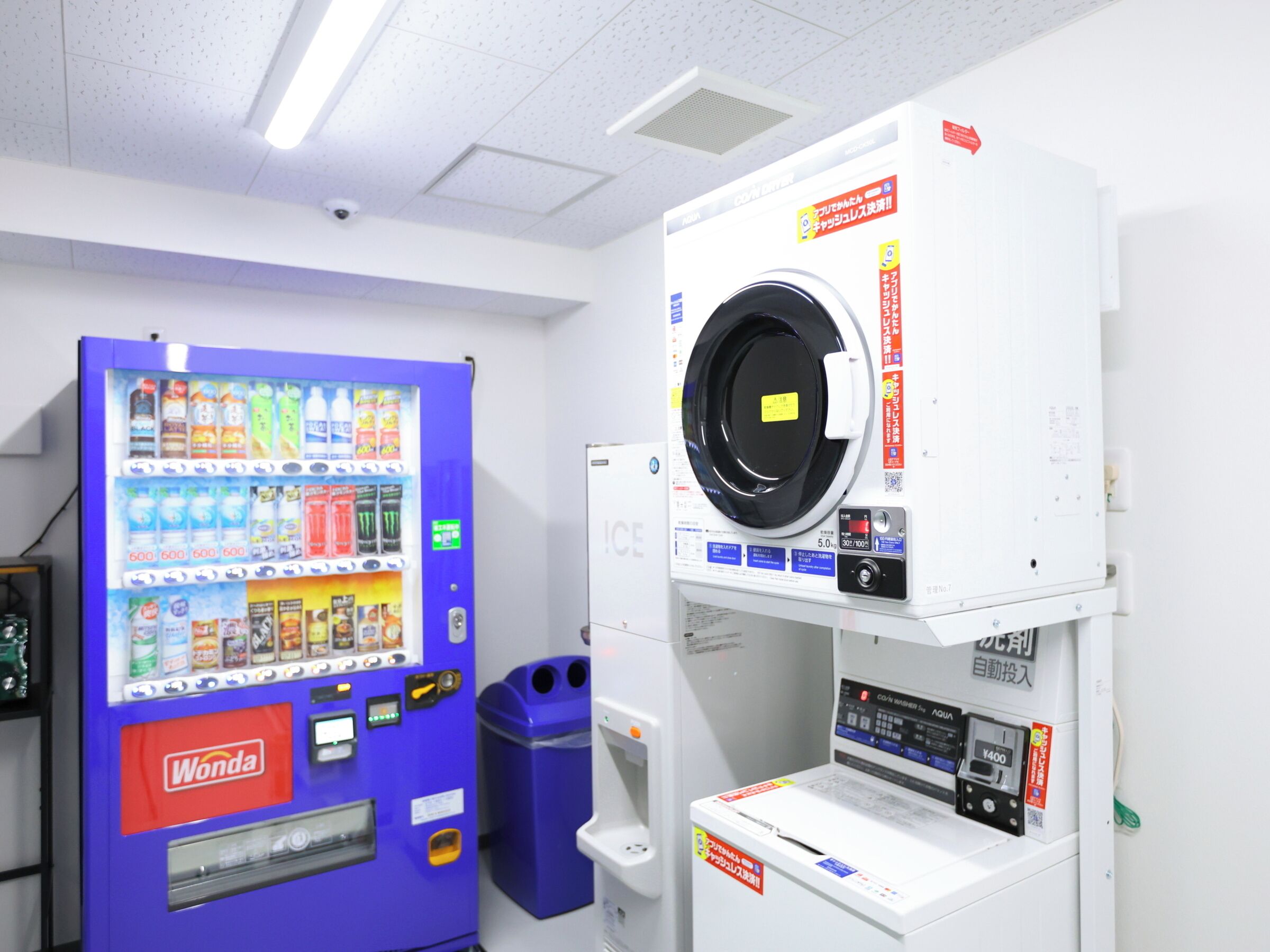 A vending machine and a washing machine in a room.