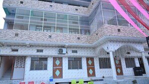 A multi-story building with a patterned facade, multiple balconies, and a staircase leading to the entrance. - Shri Sita Vallabh Padchhaya (Ayodhya)