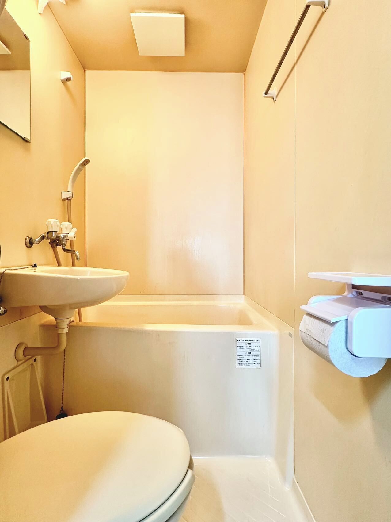 A small, compact bathroom with a toilet, sink, and bathtub.