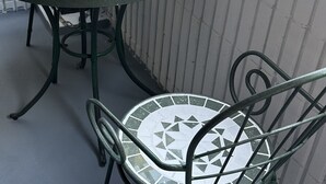 A round table with a mosaic tile design and metal chairs with matching patterns. - [ 303 ] Twin Japanese-style room with kitchen, bathroom and washing machine, 2 min. from the nearest station, along the airport line. (大阪市)