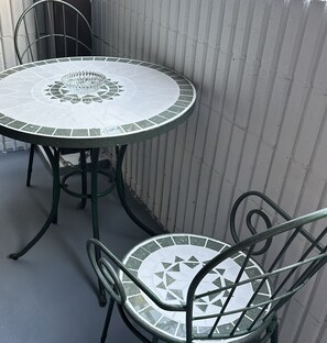 Sit around the vibrant mosaic table, surrounded by a metal frame and two matching chairs.