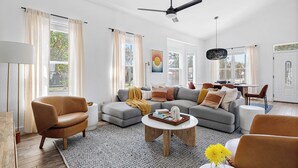 A modern living room with a grey sofa, a coffee table, and a ceiling fan.