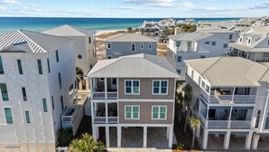 Ein Wohngebiet direkt am Strand mit mehrstöckigen Gebäuden, Balkonen und Blick auf den Ozean.