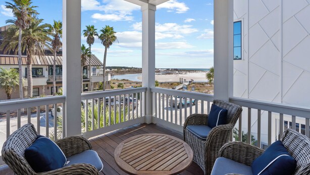 Ein Balkon mit Korbmöbeln und Blick auf den Strand.