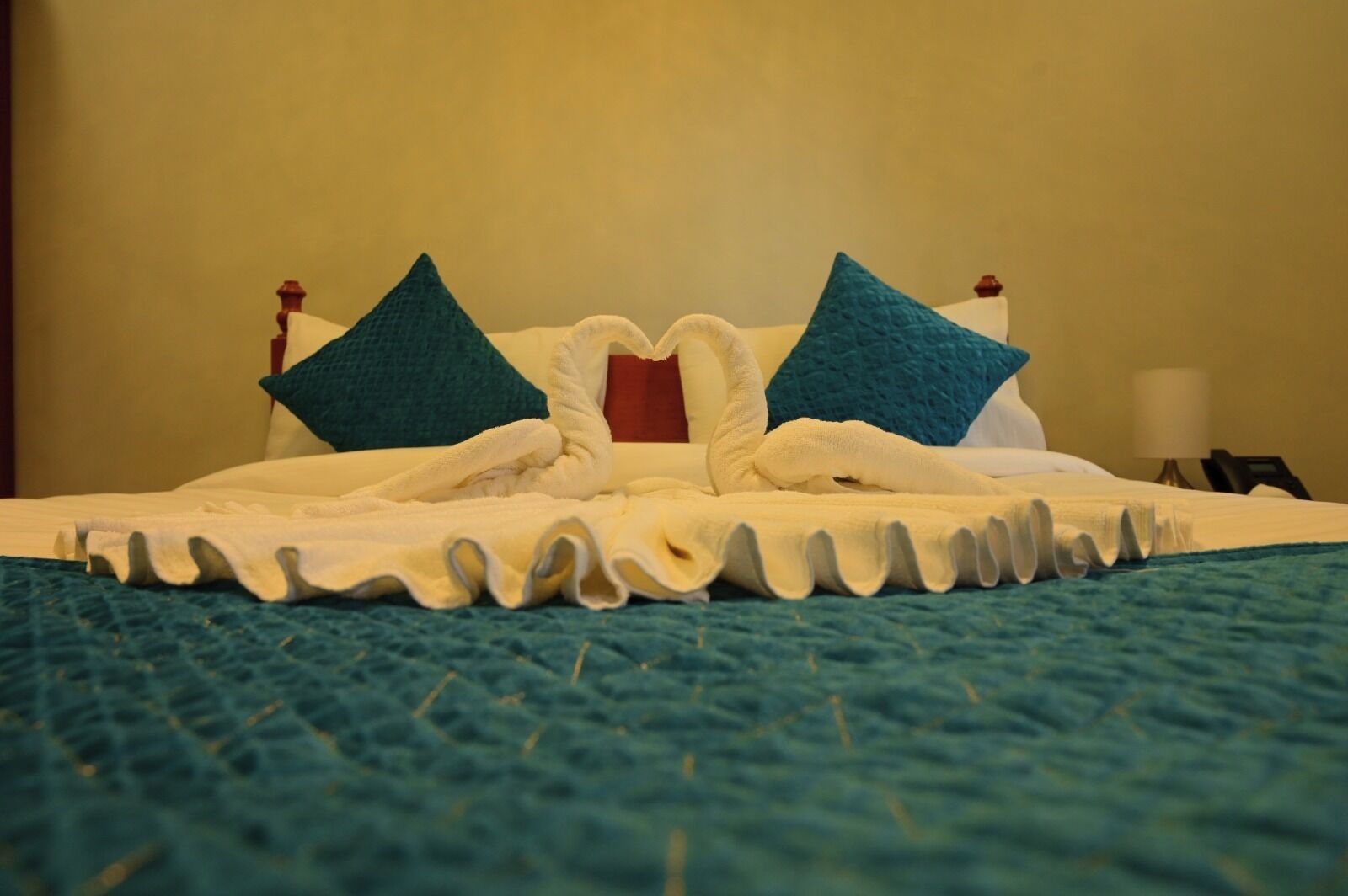 A neatly made bed with a white duvet, two pillows, and a decorative headboard.