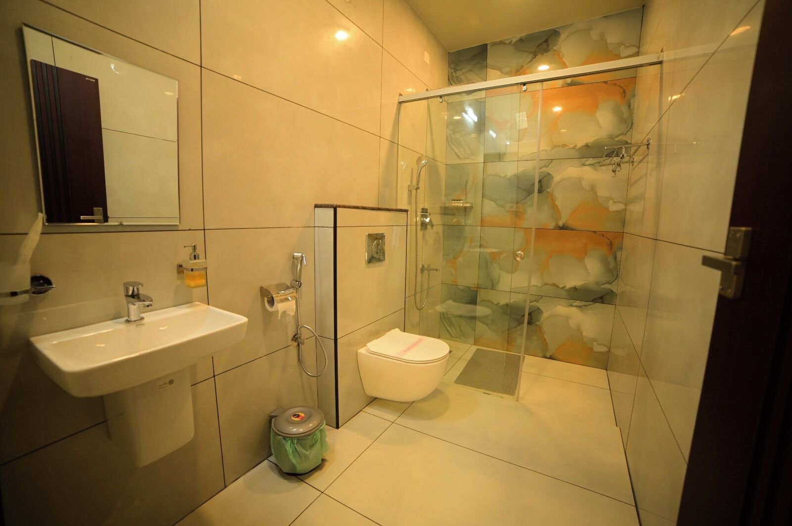 A modern bathroom with a glass shower enclosure, a sink, and a toilet.