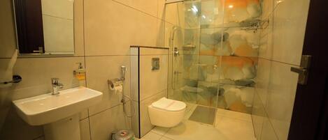 A modern bathroom with a glass shower enclosure, a sink, and a toilet.