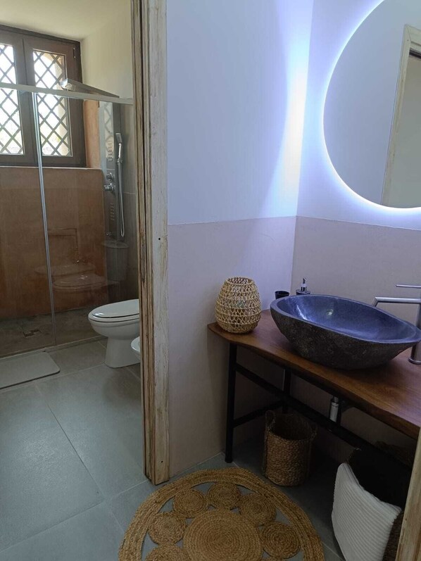 Un baño con ducha, inodoro y lavamanos.