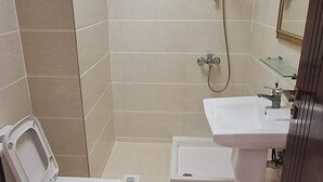 A bathroom with a toilet, bidet, shower, and sink. - STAR 4 SEASON (Salalah)