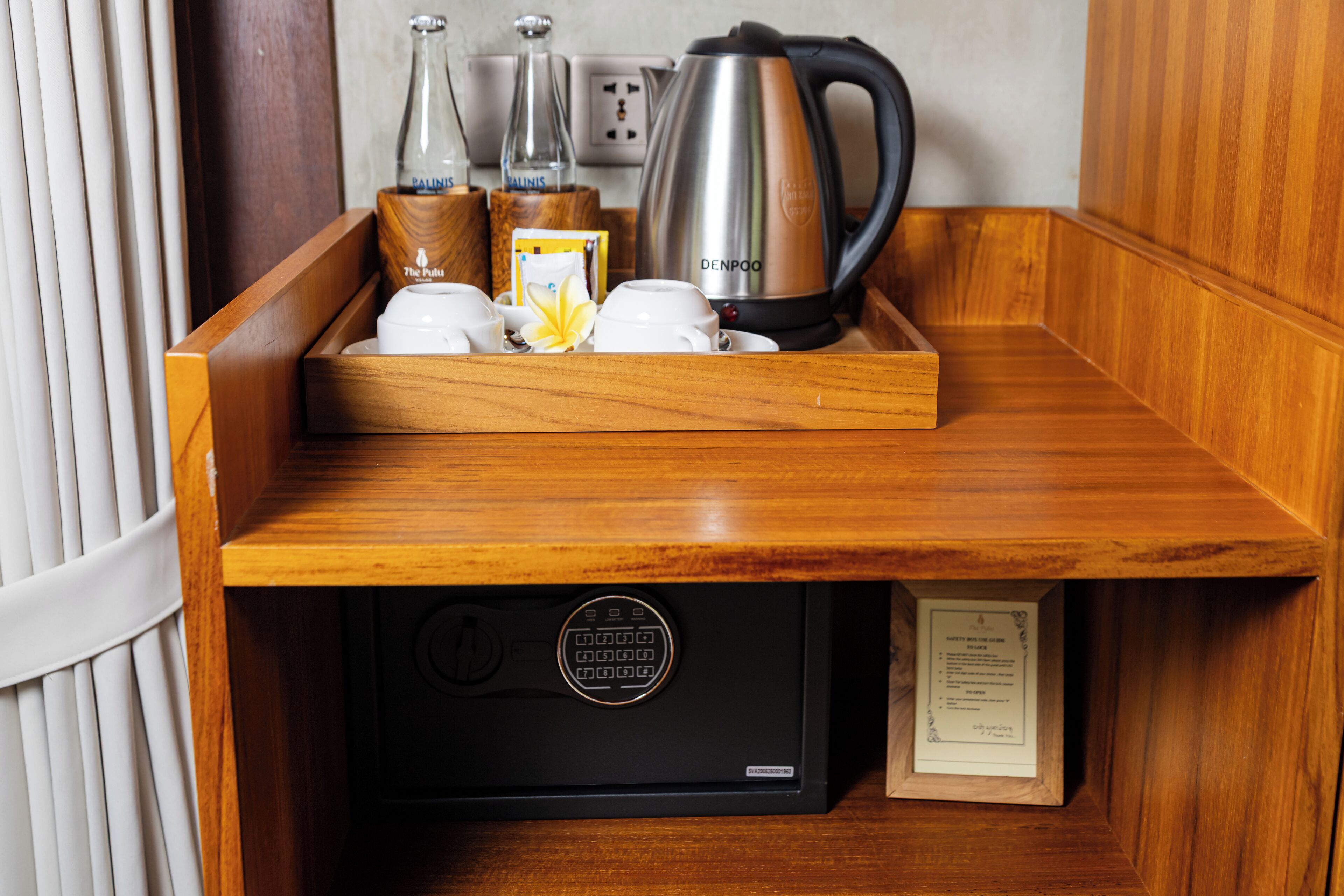 A wooden tray with a coffee maker, teapot, and cups on a wooden counter.