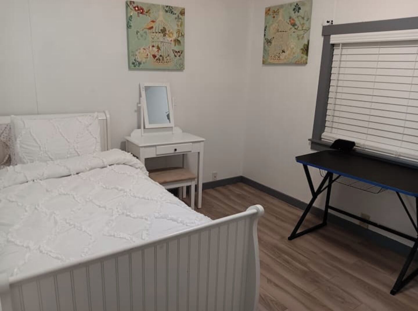 Una camera da letto con un letto, una scrivania e una finestra con persiane.