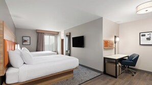 A hotel room with a bed, a desk, a chair, a TV, and a window with curtains. - Candlewood Suites Shelbyville by IHG (Shelbyville)