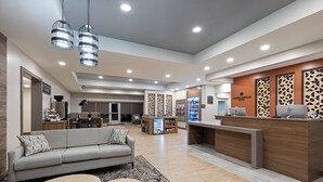 A modern hotel lobby with a reception desk, seating area, and a coffee station. - Candlewood Suites Shelbyville by IHG (Shelbyville)